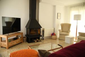 a living room with a fireplace and a tv at La Mimosa de Hazas, Cantabria Mar y Montaña in Hazas de Cesto