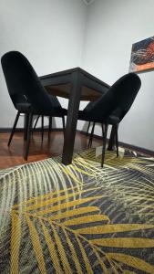 a black table and two chairs on a rug at HOPE-always in Cape Town
