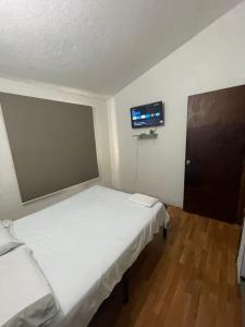 a room with two beds and a tv on the wall at Apartamento mejor zona residencial in Cúcuta