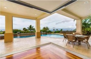 a patio with a table and chairs and a swimming pool at Breathtaking Oceanfront Lahaina Villa in Lahaina +58 photos