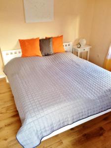 a large bed with orange pillows on top of it at Ferienwohnung Erhol Dich Gut in Diez