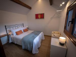 a bedroom with a bed and a table with a lamp at Casa volcánica El Cabezo in Masdache