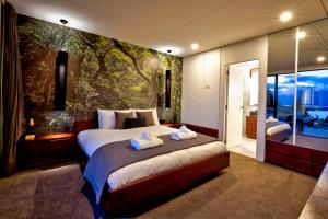 a bedroom with a large bed and a wall mural at Mountain Lake Vista 3 Bedroom in Queenstown +14 photos