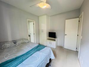 Un dormitorio con una cama y un televisor de pantalla plana. en Apartamento Porto Real - Mangaratiba, en Mangaratiba