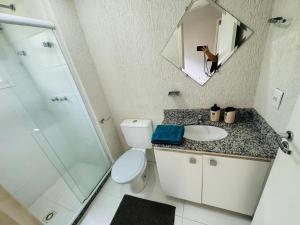 Un baño con inodoro, lavabo y espejo. en Apartamento Porto Real - Mangaratiba, en Mangaratiba 17 fotos más
