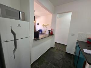 a kitchen with a white refrigerator and a counter at Jaboticabal 403A in Jabuticabal