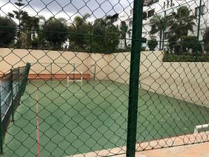 a tennis court behind a chain link fence at Appartement marina beach f5 n6 in M'diq