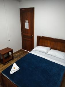 a bedroom with a large bed with a blue blanket at Hotel Café Arábico in Líbano +11 photos