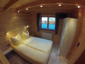 Kleines Zimmer mit einem Bett und einem Kühlschrank. in der Unterkunft Spreewaldhäuser Wiesner in Lübbenau