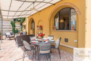 Un patio con una mesa y sillas en un patio. en Villa Le Tortore privata lusso piscina relax Siena, en Siena