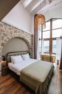 a bedroom with a large bed with a stone wall at Boho Garden Selimiye in Selimiye