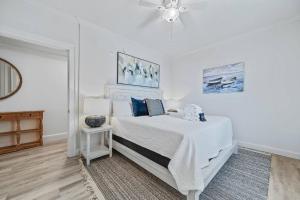 a white bedroom with a bed and a ceiling fan at Perdido Dunes Tower 2 East in Orange Beach