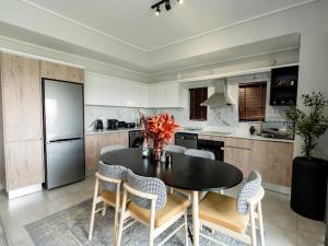 a kitchen with a table with chairs and a refrigerator at 347 Waterfall Penthouse in Midrand