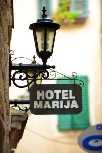 a street light with a hotel marina sign on a building at Hotel Marija in Kotor