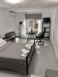 a bedroom with a bed and a desk and chairs at Rethymno Central Studio in Áyios Andónios