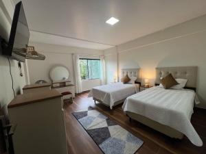 a large bedroom with two beds and a window at Casa Jardín Tarija in Tarija