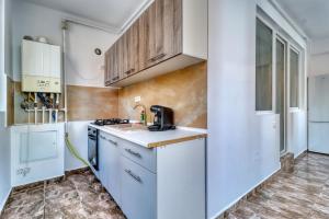 a kitchen with white cabinets and a counter top at Militari Residence Apartament 3 camere in Roşu +11 photos