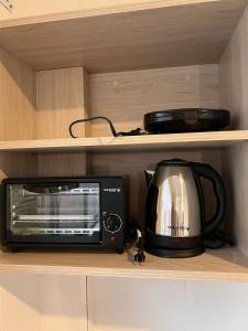 a microwave and a toaster oven sitting on a shelf at Casa Jardín Tarija in Tarija