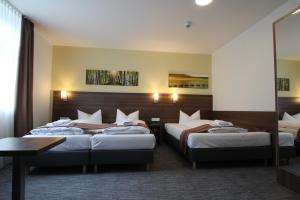 um quarto de hotel com duas camas e uma mesa em Goethe Conference Hotel by Trip Inn em Frankfurt