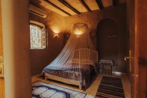 a bedroom with a bed with a mosquito net at Desert Rose Guesthouse in Luxor