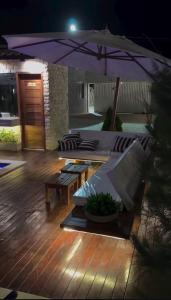 a patio with benches and an umbrella at night at Barra Grande Condomínio Vila Eco BG Apt T11 in Cajueiro