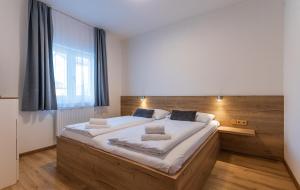 sypialnia z dużym łóżkiem z białą pościelą w obiekcie Apartmán Lipno G11 w mieście Frymburk