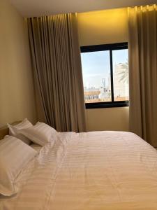 a bedroom with a large white bed with a window at شقه فاخره وسط حي السليمانيه in Riyadh