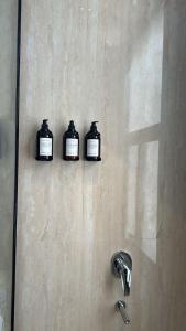 three bottles on the wall of a shower at شقه فاخره وسط حي السليمانيه in Riyadh