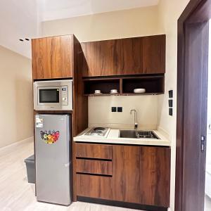 a small kitchen with a refrigerator and a microwave at شقه فاخره وسط حي السليمانيه in Riyadh