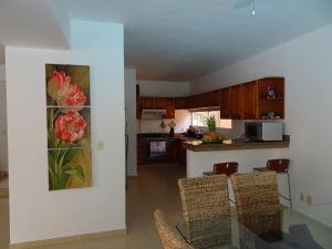 a kitchen with a painting of flowers on the wall at La Salamandra in Puerto Aventuras