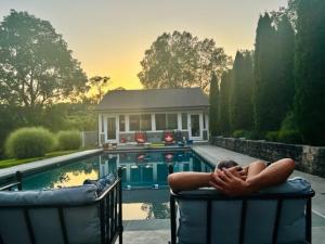 Una mujer recostada en una silla junto a una piscina. en Fox Hollow Farm, en Middletown 9 fotos más