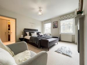 a bedroom with a bed and a couch and a chair at 3-Bed gem with Bath Abbey views in Bath