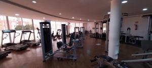 a gym with rows of tread machines in a room at Piatã apartamento com Clube in Salvador
