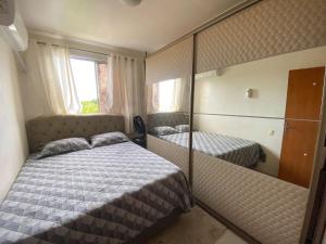 a small bedroom with two beds and a mirror at COP30 aluguel in Marituba