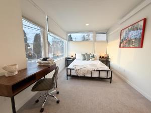 a bedroom with a bed and a desk and window at Hot Tub - Best Views - Near Stadiums! in Seattle