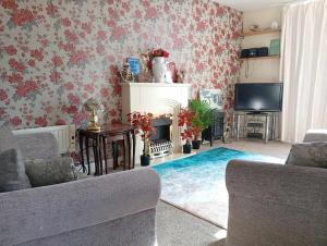 a living room with a fireplace and floral wallpaper at yeolde woodern country View seashak BONFIRE NOV SPECIALS FREE electric LOW PRICES ENJOY BRING YOUR DOG in Bridlington