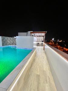 a swimming pool on the roof of a building at night at Hotel Gboss in Punta Hermosa +29 photos