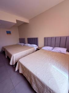 two beds sitting next to each other in a room at Hotel Gboss in Punta Hermosa