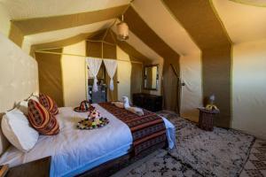 a bedroom with a large bed with animals on it at Soul Dunes Luxury Camp in Merzouga