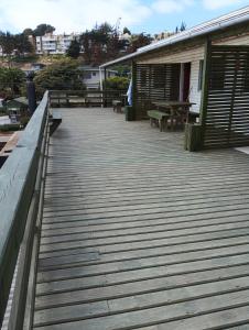 a wooden deck with benches and a building at Cabañas La Laguna de Zapallar in La Laguna