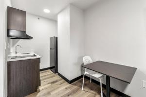 a small kitchen with a table and a refrigerator at Southern Suites Forest Park in Forest Park +5 photos