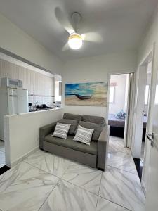 a living room with a couch and a kitchen at apartamento próximo a praia condomínio ubirajara in Praia Grande