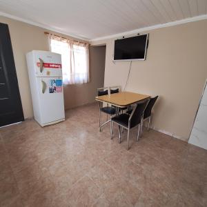 Un comedor con una mesa y un refrigerador. en Hospedaje Calel, en Gobernador Gregores