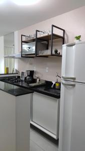 a kitchen with white cabinets and a white refrigerator at Flat Studio in João Pessoa
