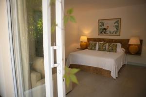 a bedroom with a bed with two lamps and a window at El Bosque Hotel Boutique in Doradal +39 photos