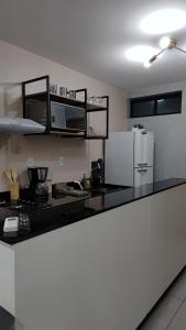 a kitchen with a counter top with a microwave and refrigerator at Flat Studio in João Pessoa +4 photos