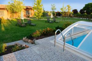 un patio con piscina y un patio con sillas en Casale Belriguardo, en Ferrara