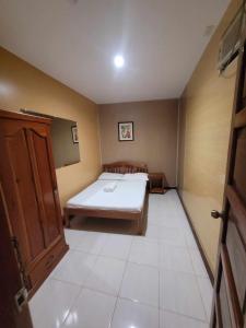 a small room with a bed and a door at La Belle Staycation Budget Room in Puerto Princesa City