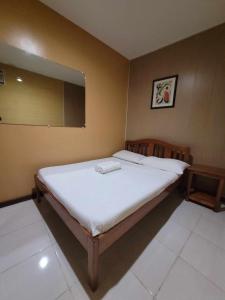 a bedroom with a large bed with a mirror at La Belle Staycation Budget Room in Puerto Princesa City