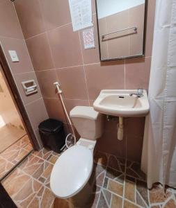 a bathroom with a toilet and a sink at La Belle Staycation Budget Room in Puerto Princesa City